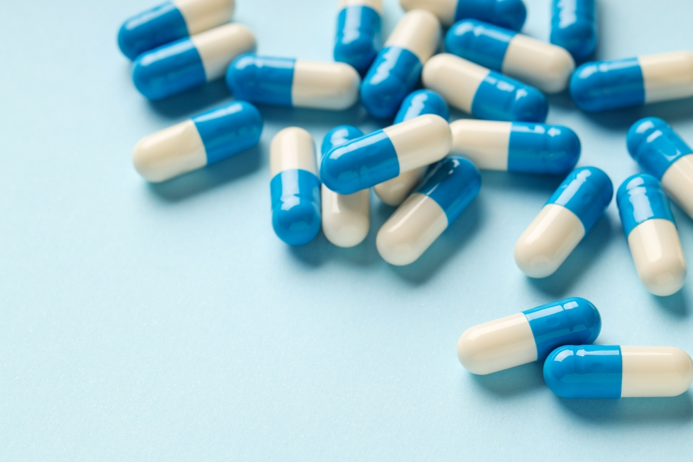 pile of white and blue antibiotic capsules